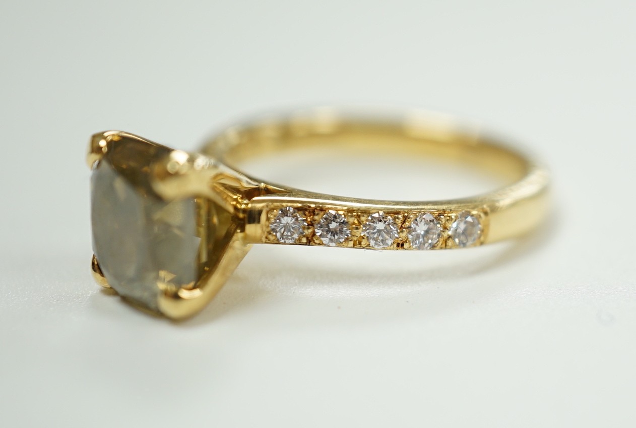 A modern 18ct gold and single stone cut cornered rectangular modified brilliant cut fancy dark brown-greenish yellow diamond, with diamond set shoulders and accompanying GIA report dated 20/12/2013, stating the stone to